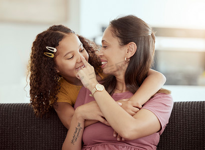 混血单身母亲和女儿在家里的客厅里拥抱。