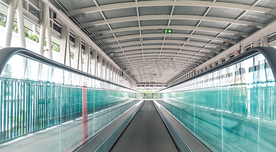 国际机场自动扶梯现代走道向前移动，自动扶梯向后移动。