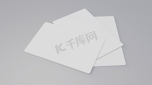 礼品卡模板摄影照片_白色礼品卡信用卡样机堆叠在灰色桌子背景上。