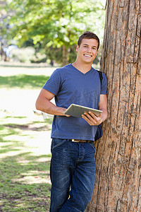 一名学生靠在树上触摸的肖像