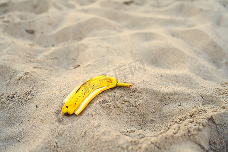 水在自然界的循环摄影照片_躺在沙滩上的香蕉皮。