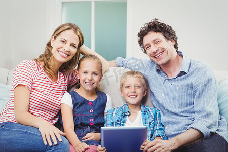 幸福的家庭，坐在沙发上的数字平板电脑