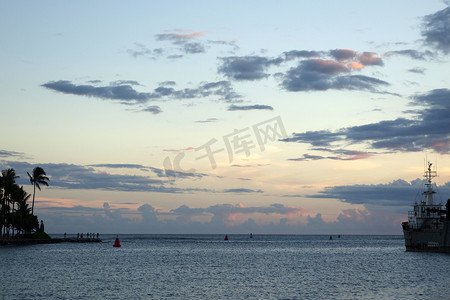 大海黄昏摄影照片_黄昏时分，科瓦洛盆地港向大海开放，人们站在岸上观看日落，船停靠在码头
