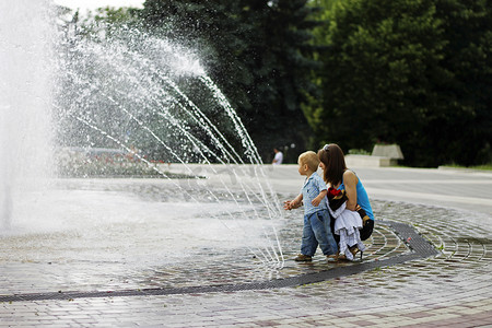 妇女和儿童在中心 o 周围走动泼水喷泉
