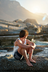 日落真实摄影照片_年轻人坐在海滩上看日落看海洋思考旅程