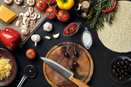 比萨原料摄影照片_用传统的比萨准备原料切割木板：奶酪、番茄酱、罗勒、橄榄油、胡椒、香料。