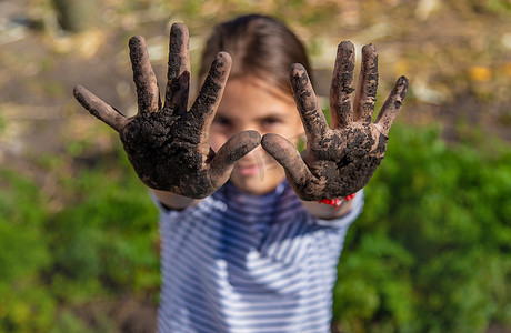 孩子在花园里拿着泥土。