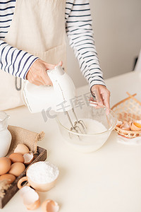 酥蛋黄摄影照片_男手在碗里用搅拌器打蛋清奶油