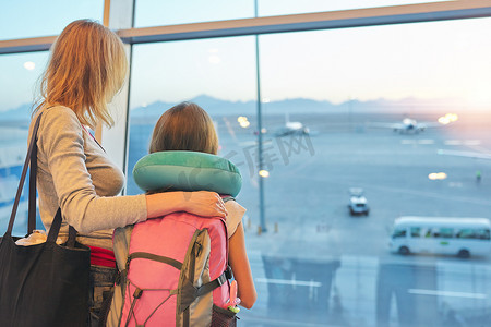 机场乘客家庭母女在全景窗口看飞机