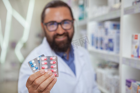 医生卖药摄影照片_快乐的药剂师在他的药店卖药