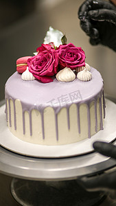 人像图标磨砂摄影照片_设计师用标志装饰磨砂丁香浪漫生日快乐蛋糕顶部