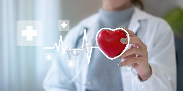 私人诊所摄影照片_心脏病专家在私人诊所拿着红心。