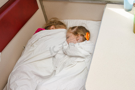 两个孩子睡在火车上二等车厢同一地面位置