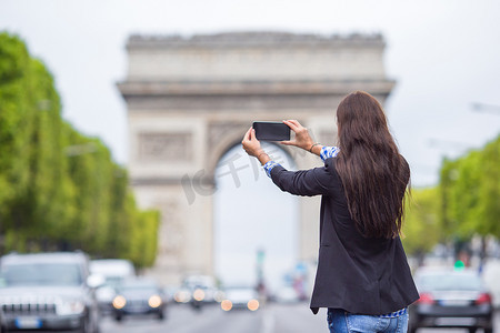 巴黎香榭丽舍大街上用手机拍照的年轻女子