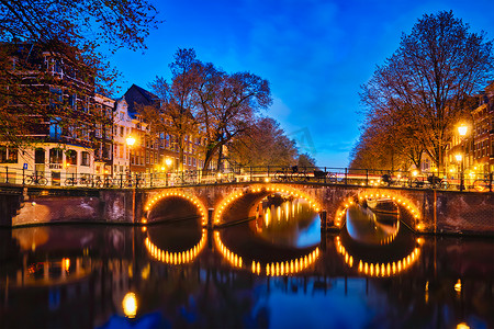 阿姆斯特丹运河、桥梁和中世纪房屋在晚上