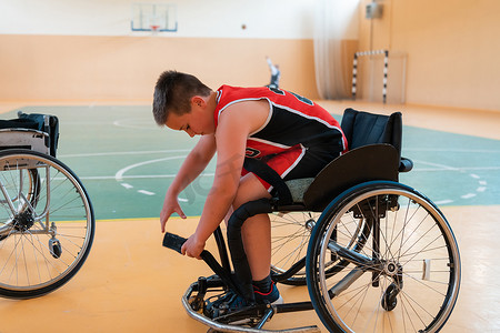 男孩坐在轮椅上，为大竞技场的篮球比赛做准备