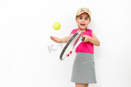 工作室拍摄的一个微笑的小女孩穿着粉色 T 恤和白色裙子-白色背景下的网球运动服。