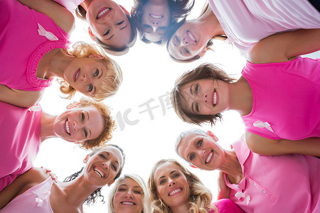 开朗的女性围成一圈，穿着粉色衣服治疗乳腺癌