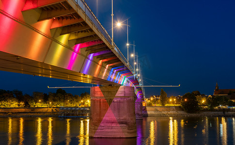 彩灯背景图摄影照片_诺维萨德夜间多瑙河上美丽的桥梁彩灯景观