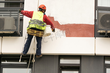 粉刷滚筒摄影照片_建筑工人正在用滚筒粉刷墙壁