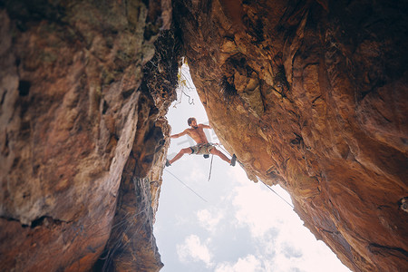 极限攀岩摄影照片_登山或攀岩、悬崖悬吊和肾上腺素瘾君子，勇于冒险，试图平衡差距。