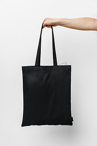 白色背景下女性手持生态或可重复使用的购物袋