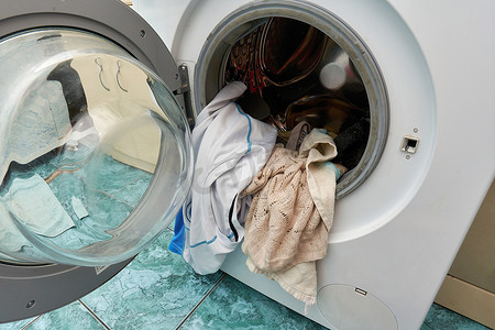 洗衣摄影照片_带开门的洗衣机和放在洗衣桶中的脏衣服