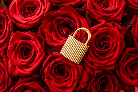 情人节玫瑰金摄影照片_情人节卡片的爱锁、金挂锁和红色背景的豪华玫瑰花束