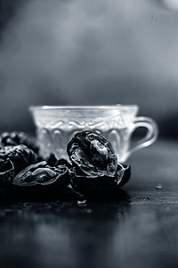 透明玻璃杯中壁坚果或核桃茶的草药有机茶的特写，壳内有生壁坚果，也破碎。