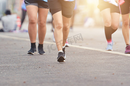 马拉松在傍晚的灯光下跑步，健康的人群在跟踪路上慢跑，健身跑步减肥。