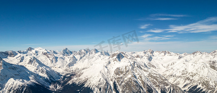 蓝天背景下俄罗斯高加索地区雪冬山脉全景