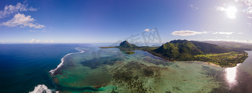 Le Morne 海滩毛里求斯，带棕榈树和白色沙滩蓝色海洋的热带海滩和带雨伞的沙滩床、太阳椅和遮阳伞在热带海滩的棕榈树下，Le Morne 海滩毛里求斯