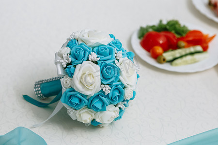 躺在桌子上的蓝色婚礼花束。