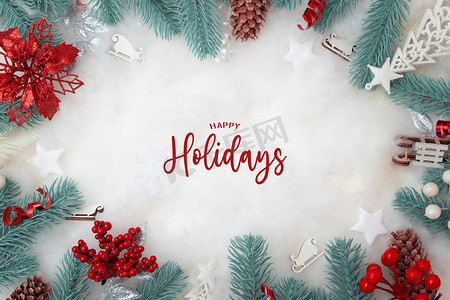 金色雪花背景图摄影照片_Happy Holidays 文字，框架由圣诞装饰制成，平铺在雪地背景上，有复制空间