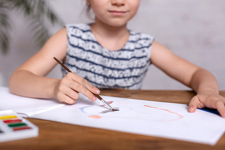 在桌上受到启发的小女孩用颜料画画。