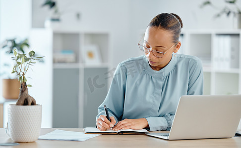 严肃、思考和自信的财务经理在笔记本或办公室的书本上写笔记。