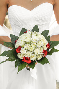 手捧白玫瑰摄影照片_新娘捧着一束红玫瑰和白玫瑰
