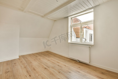 有白色墙壁和镶木地板的阁楼空房间