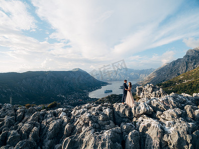 新郎和新娘站在山上俯瞰科托尔湾的山谷