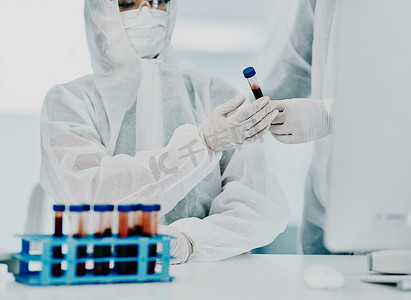 科学家们用防护个人防护设备测试了新冠病毒的血样，以防止病毒在医院传播。
