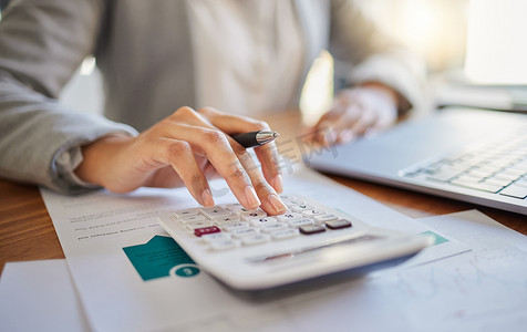 在办公室与财务规划师或顾问一起使用笔记本电脑和计算器进行财务、预算和会计。