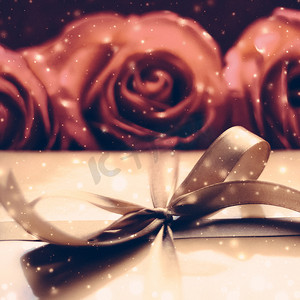 圣诞节礼物棒摄影照片_豪华假日金色礼盒和玫瑰花束作为圣诞节、情人节或生日礼物