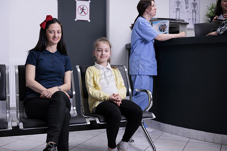 微笑的妇女和她的孩子在私人诊所接受儿科医生预约