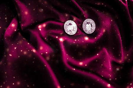 深红色丝绸上的奢华钻石耳环，雪光闪闪，节日冬季魔法珠宝礼物