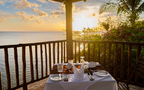 日落时的餐桌，浪漫的海边晚餐，欣赏美丽的加勒比海