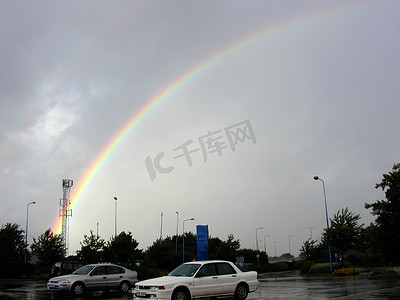 彩虹拱在雨水浸透的停车场上