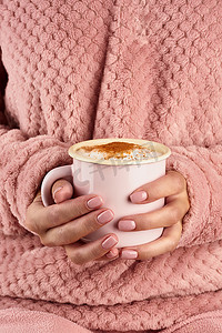 在寒冷的秋天早晨，双手捧着早晨的热巧克力