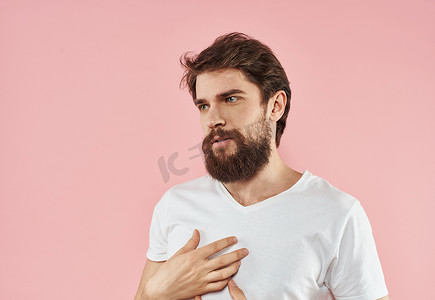 一个留着胡子和胡子的男人，在粉红色的背景下用手做手势
