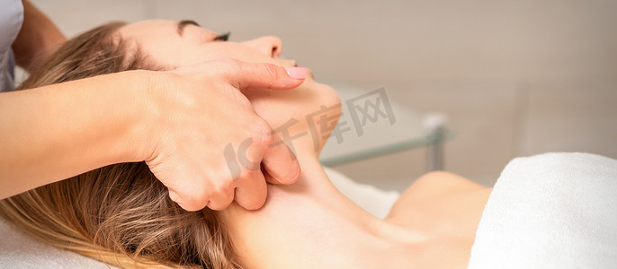 美容师在美容院进行淋巴引流面部按摩或整容按摩。