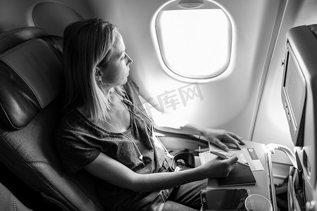 随意的女人乘坐商业客运飞机，填写移民表格。